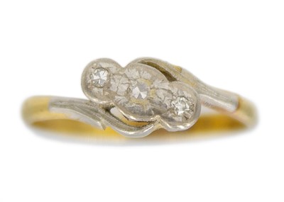 Lot 86 - An 18k gold and platinum three-stone diamond set overlap ring.