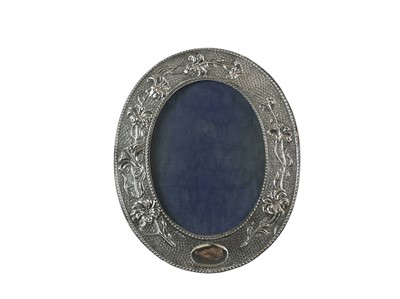 Lot 242 - An Edwardian silver easel photograph frame of oval form.