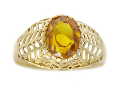 Lot 152 - An 18k gold synthetic yellow sapphire set ring.
