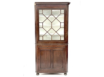 Lot 511 - A George III oak glazed corner cupboard.