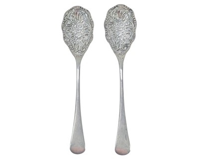 Lot 240 - A pair of silver serving spoons, the bowls repousse decorated with a floral design.