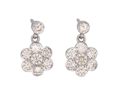 Lot 132 - A pair of 18k white gold daisy-style diamond set cluster pendant earrings.