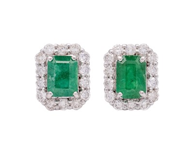 Lot 134 - A pair of 18k white gold emerald and diamond set stud earrings.