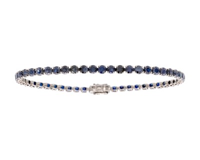 Lot 140 - An 18k blackened gold sapphire line bracelet.