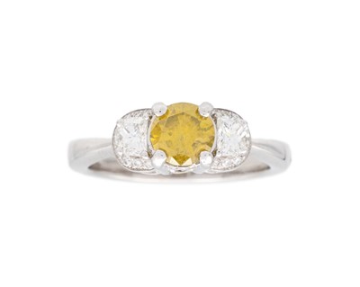 Lot 193 - A 14k white gold three-stone yellow and white diamond ring.