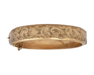 Lot 184 - A 9k gold bangle bracelet with a safety chain.