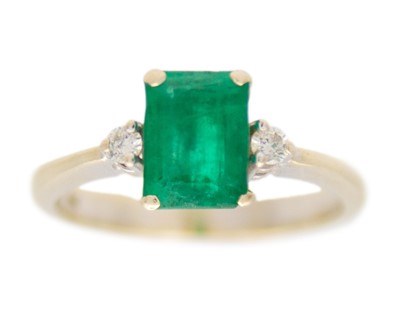 Lot 59 - An 18k white gold, emerald, and diamond ring.