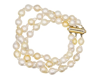 Lot 67 - A three-row golden South Sea cultured semi-baroque pearl bracelet.