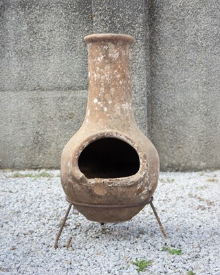 Lot 830 - A terracotta chiminea on wrought iron stand.