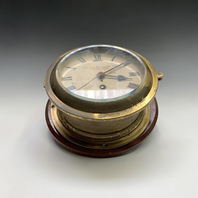 Lot 2908 - A ships brass bulkhead clock, the white...