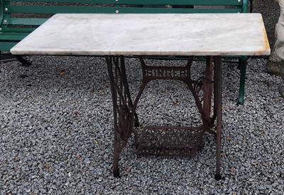 Lot 877 - A garden table. With rectangular marble top and cast iron Singer sewing machine base.