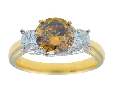 Lot 57 - An 18k yellow and white gold three-stone cognac and white diamond ring.