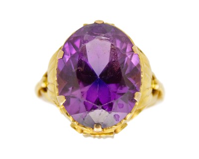 Lot 94 - A high-purity gold and purple synthetic sapphire dress ring.
