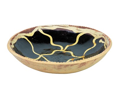 Lot 595 - A circular slipware dish.