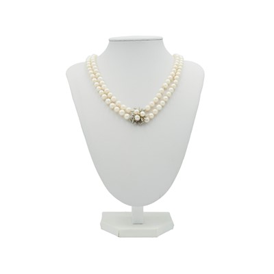 Lot 23 - A double-row cultured pearl necklace, strung to a 14k white gold diamond and pearl set clasp.