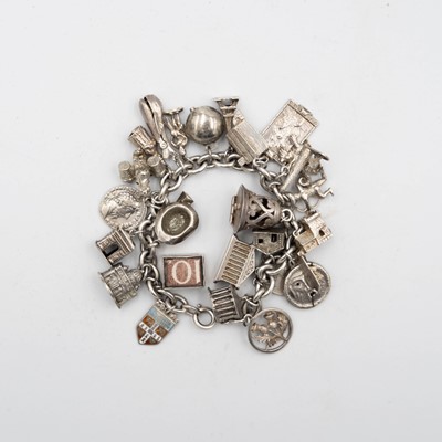 Lot 43 - A silver charm bracelet with a good selection of silver and white metal charms.