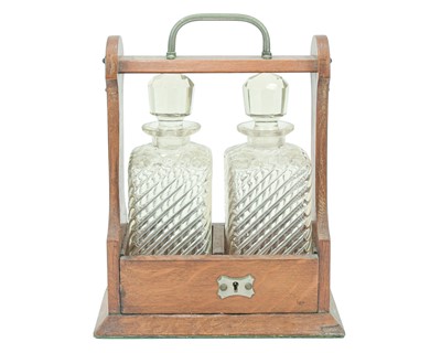 Lot 9 - An Edwardian oak two bottle tantalus.