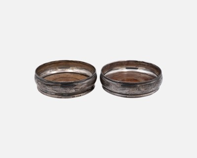 Lot 134 - Two silver-mounted wine bottle coasters.