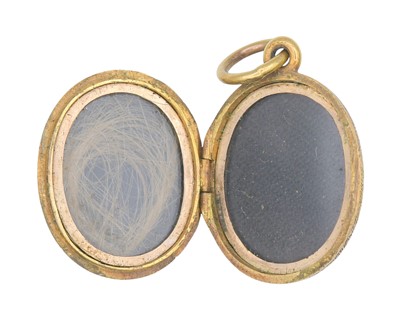 Lot 2 - A Victorian gold oval locket with foliate engraved decoration.