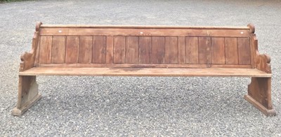 Lot 3083 - A long pitch pine church pew, with panel back,...