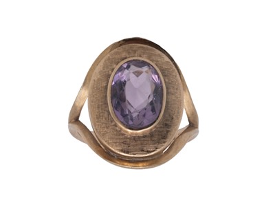 Lot 48 - A Modernist 9k oval cut amethyst set dress ring.