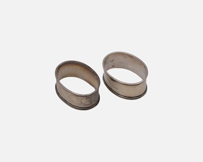 Lot 141 - A pair of silver oval form napkin rings.
