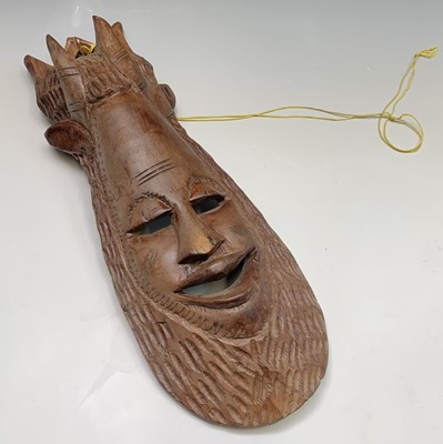 Lot 117 - An African carved wood mask. Height 54cm.
