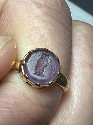 Lot 90 - John Paul COOPER (1869-1933) - An 18k ring, set with an amethyst glass owl intaglio.
