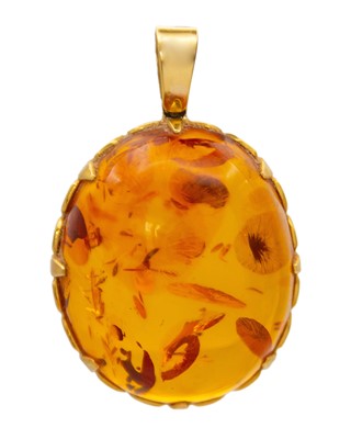Lot 163 - An 18k mounted oval cabochon amber pendant.