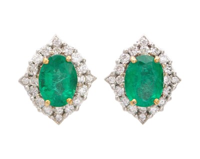 Lot 117 - A pair of 14k gold oval emerald and diamond studs.