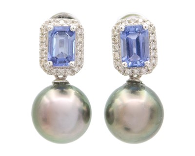Lot 132 - A pair of 18k white gold, black pearl, step‑cut sapphire and diamond drop earrings.