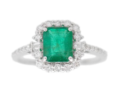 Lot 136 - An 18k white gold and step-cut emerald and diamond set ring.