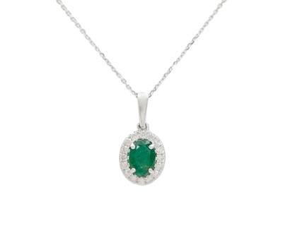 Lot 151 - A 9k white gold oval emerald and diamond cluster pendant.