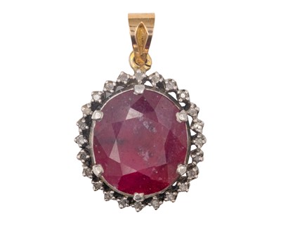Lot 232 - A large oval cut ruby and diamond set yellow and white gold pendant.
