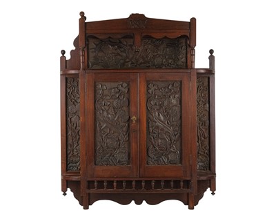 Lot 894 - A late Victorian carved mahogany hanging cupboard dated 1897.