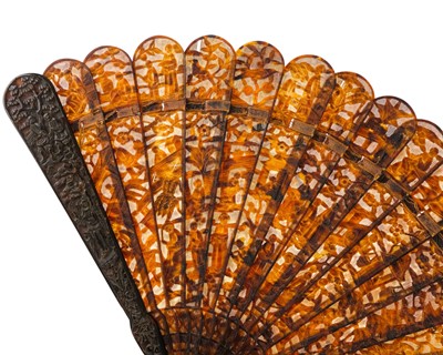 Lot 558 - A Chinese Canton carved tortoiseshell brise fan.