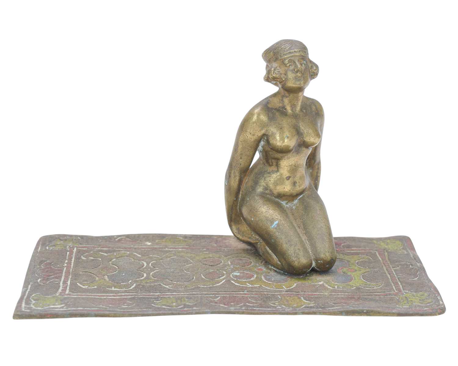 Lot 24 - A cold painted bronze figure of a female nude kneeling on a carpet.