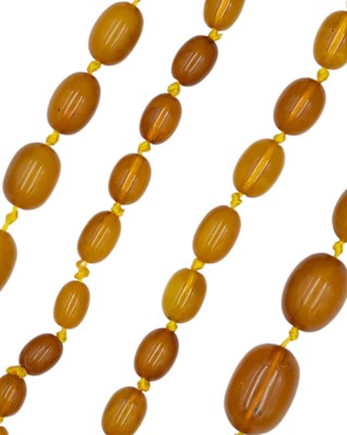 Lot 260 - An egg-yolk amber graduated oval bead necklace.