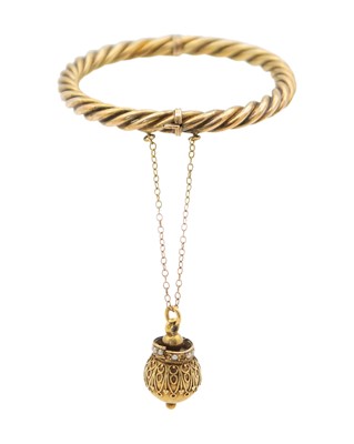 Lot 274 - A Victorian gold hollow twisted bangle, applied with a high-purity gold orb pendant.
