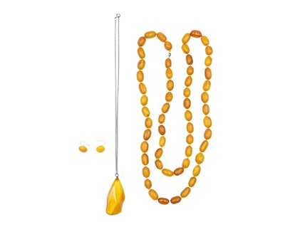 Lot 64 - A selection of amber, to include an oval bead necklace, a pair of earrings, and a pendant.