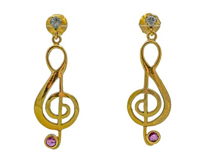 Lot 202 - A pair of yellow metal treble clef earrings, set with rubies and white sapphires.