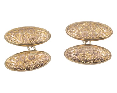 Lot 20 - A pair of 9k oval cufflinks with foliate scroll engraved decoration.