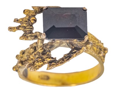 Lot 57 - A Brutalist yellow gold garnet set dress ring.