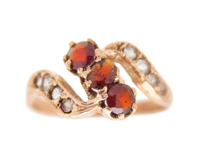 Lot 241 - A 9k rose gold garnet and CZ set ring.