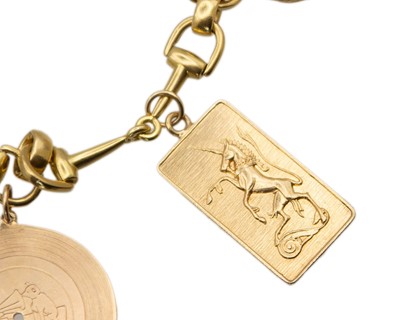 Lot An 18k hallmarked gold horse bit bracelet, applied with five gold charms.