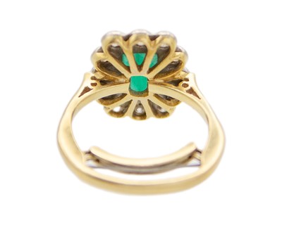 Lot 106 - An emerald and diamond set gold and platinum cluster ring.