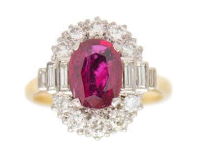 Lot An attractive oval cut ruby and diamond cluster ring.