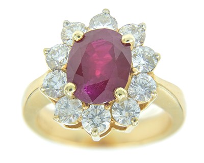 Lot 115 - An impressive diamond and oval ruby cluster ring, set in heavy yellow gold.