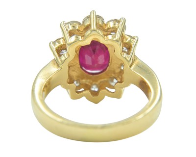 Lot 115 - An impressive diamond and oval ruby cluster ring, set in heavy yellow gold.