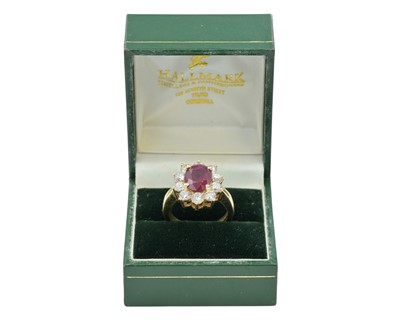 Lot 115 - An impressive diamond and oval ruby cluster ring, set in heavy yellow gold.